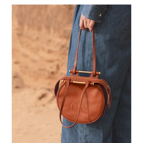 Crossbody bag on one shoulder with a top layer of calfskin commuter tote